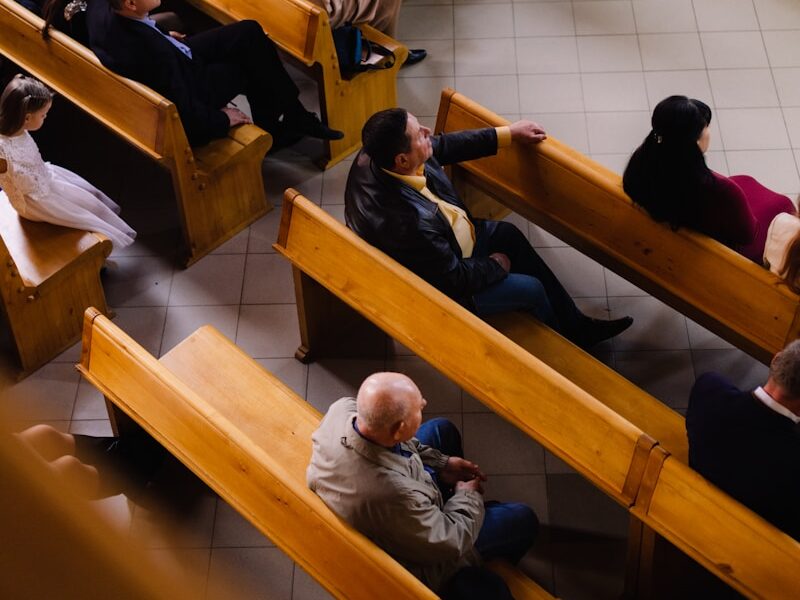 a group of people sitting in pews in a church