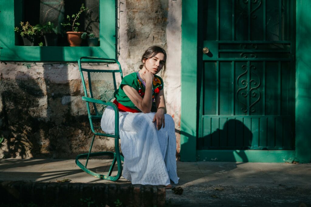 a woman sitting on a chair outside of a building