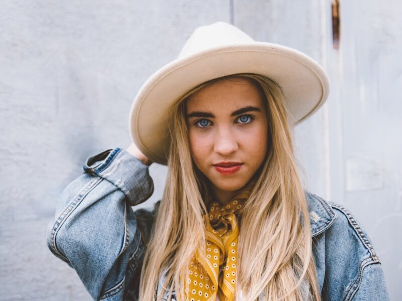 woman wearing blue denim jacket and white hat