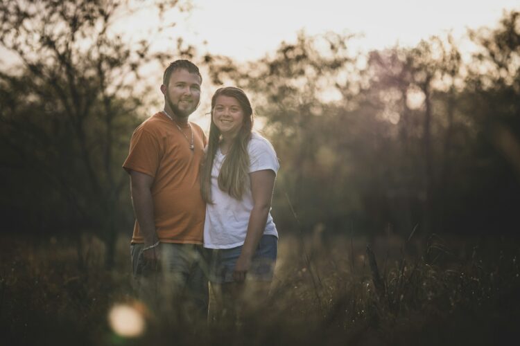 man and woman wearing T-shirt surrounded by trees