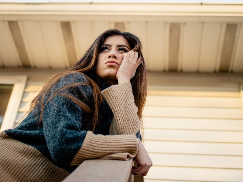 woman in blue denim jacket and brown scarf