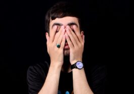 a man holding his hands to his face