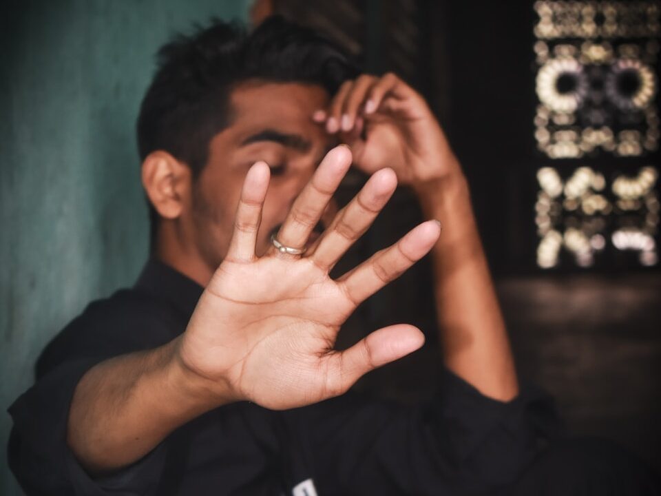 a man sitting down with his hands in the air