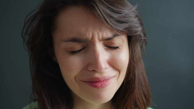 Woman with eyes closed and wrinkled nose