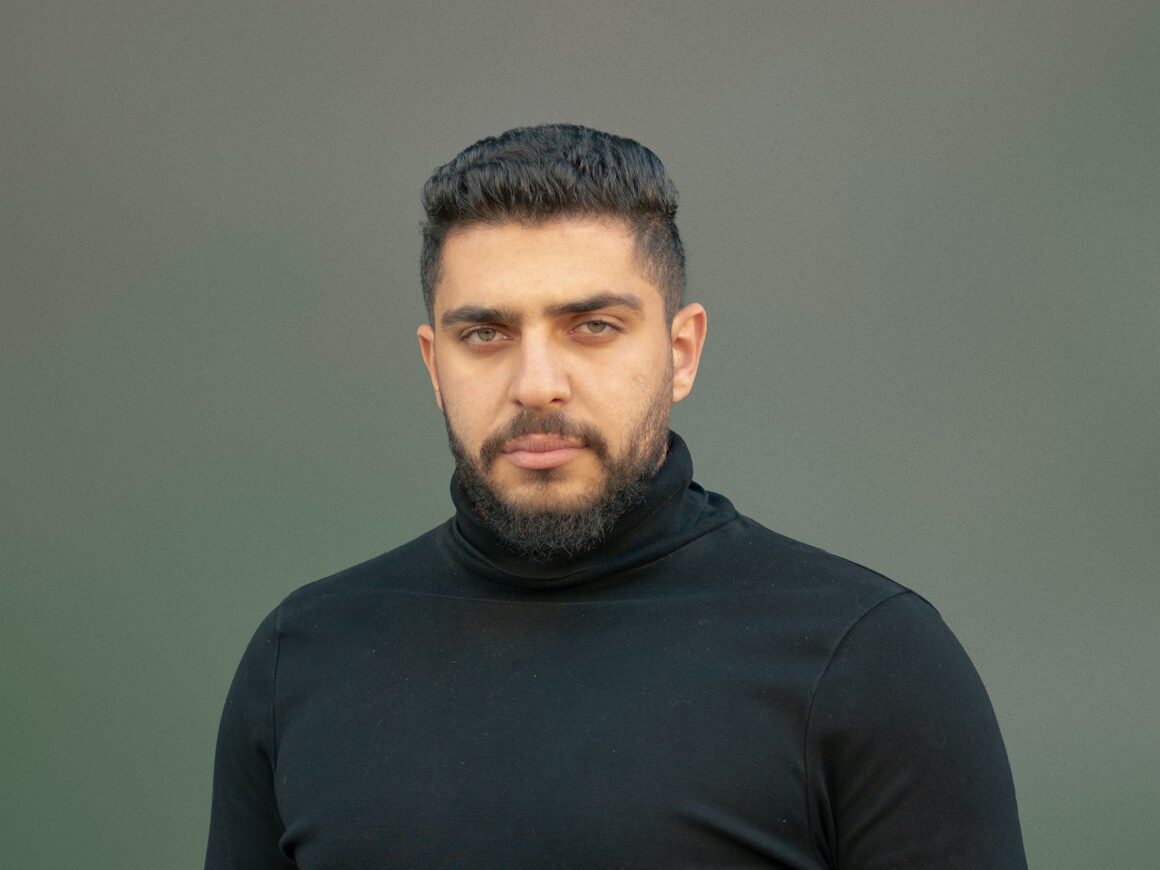 a man wearing a black turtle neck sweater