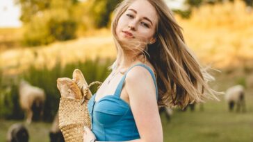 girl in white dress holding brown rabbit during daytime