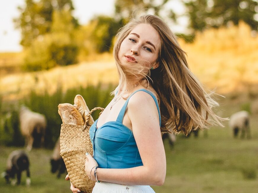 girl in white dress holding brown rabbit during daytime
