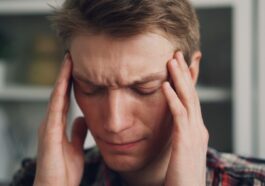 a man holding his hands to his ears