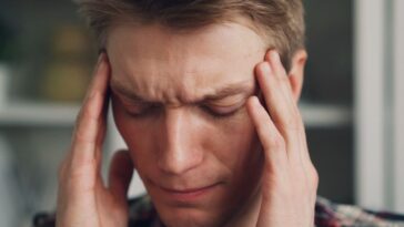 a man holding his hands to his ears