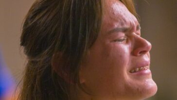 A woman with her hands folded in prayer