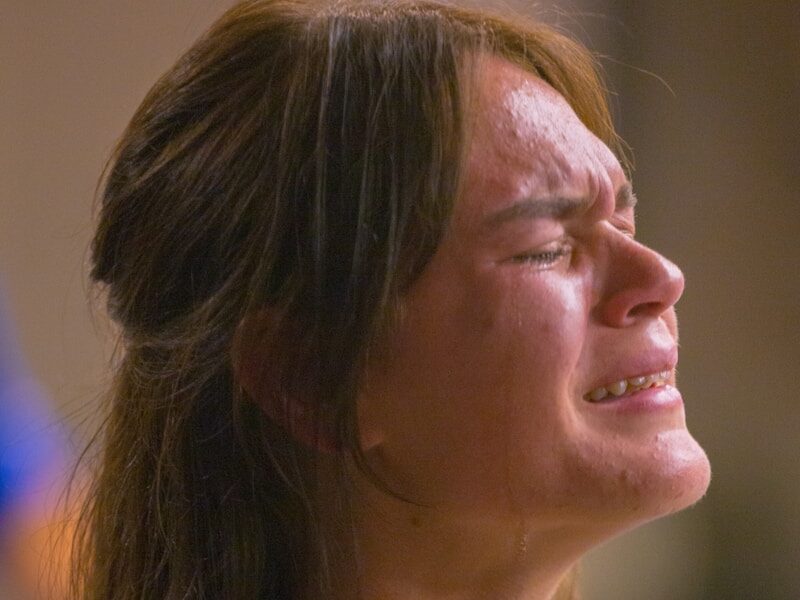 A woman with her hands folded in prayer
