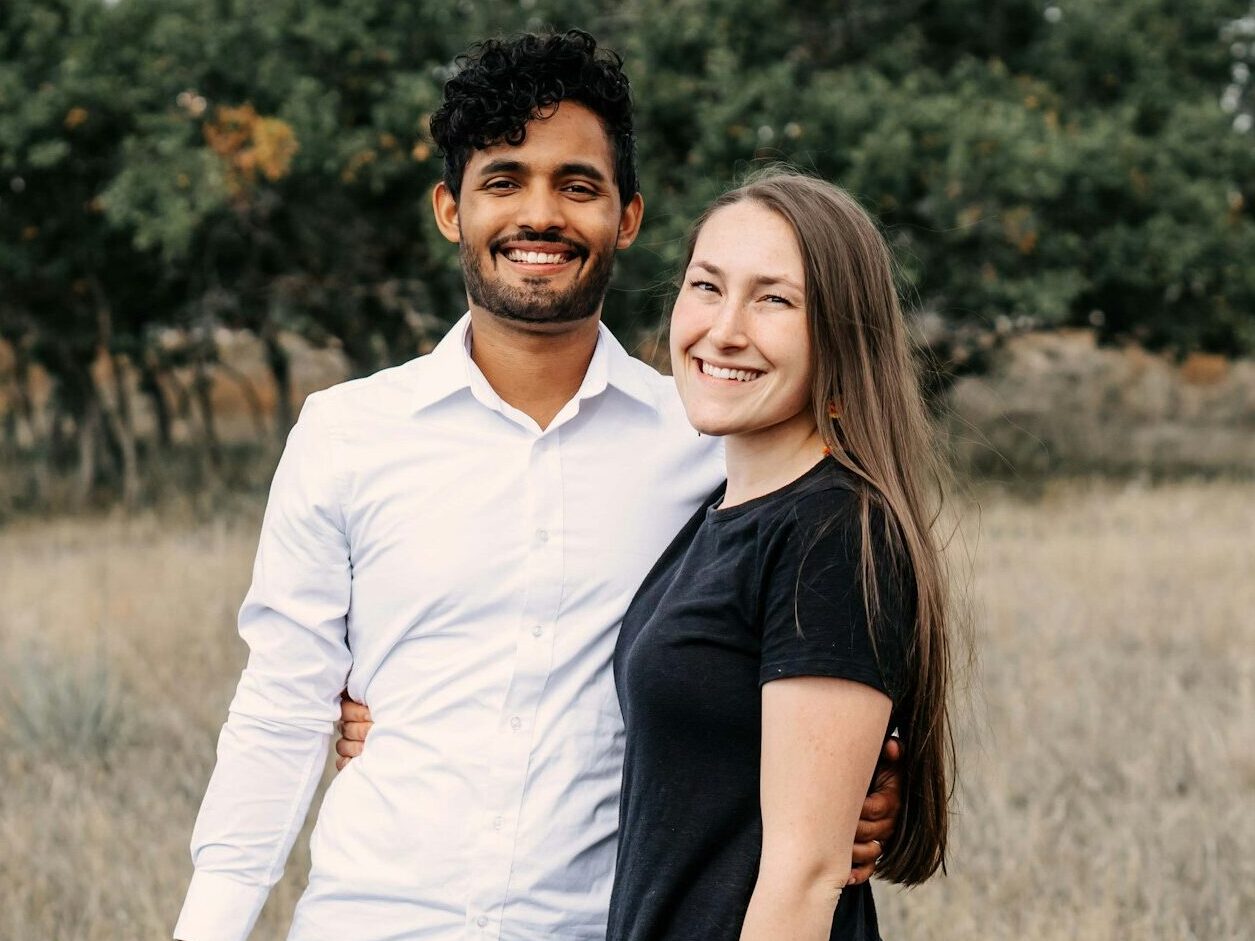 A man and a woman standing in a field