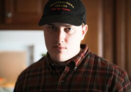 man in black and red plaid button up shirt wearing black cap