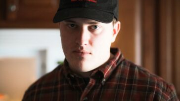 man in black and red plaid button up shirt wearing black cap