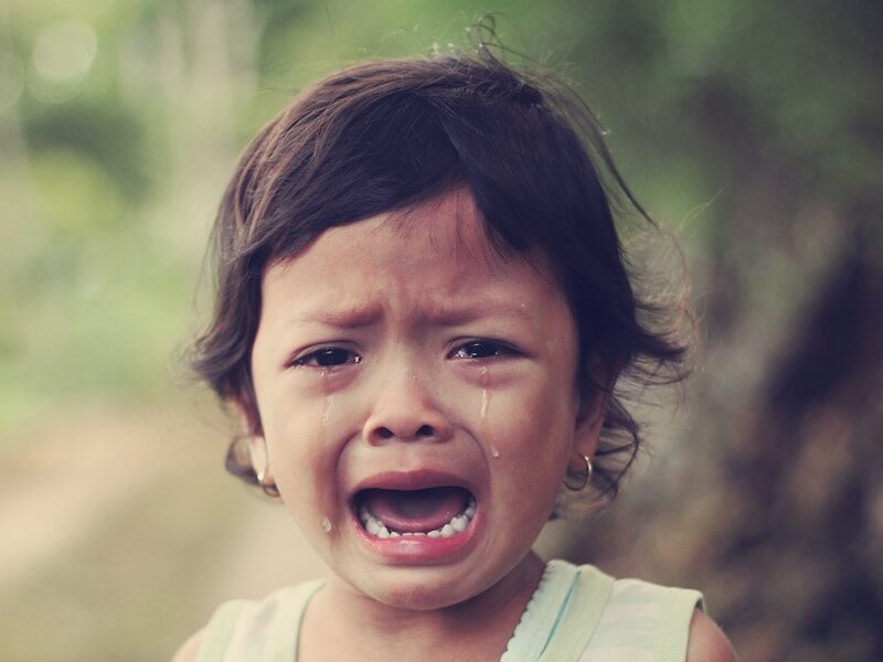 selective focus photography of girl crying