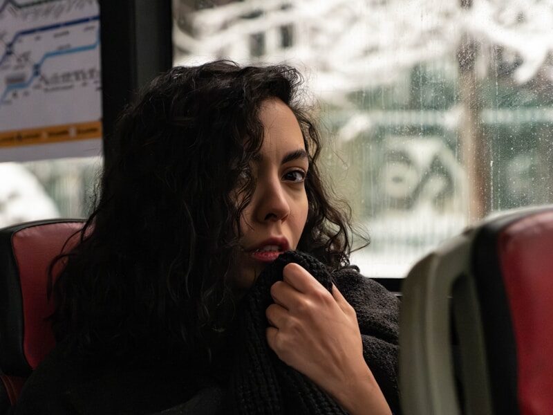 a woman sitting on a bus looking out the window