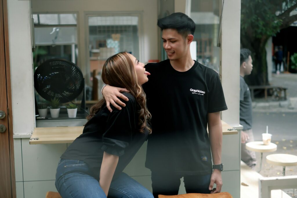 A man standing next to a woman on a bench