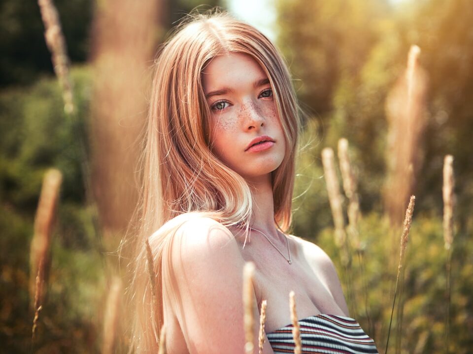 woman in black and white stripe tank top standing near brown grass during daytime