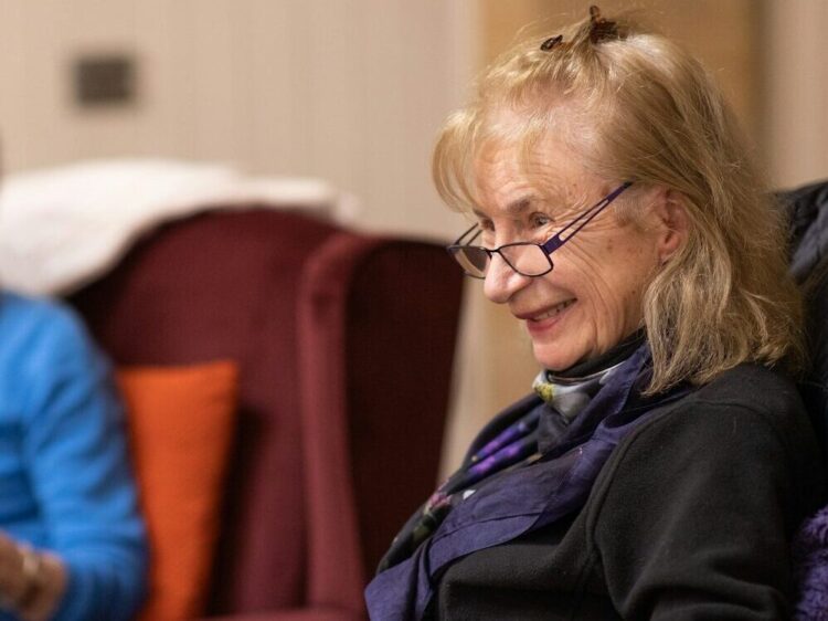 a woman sitting in a chair reading a book