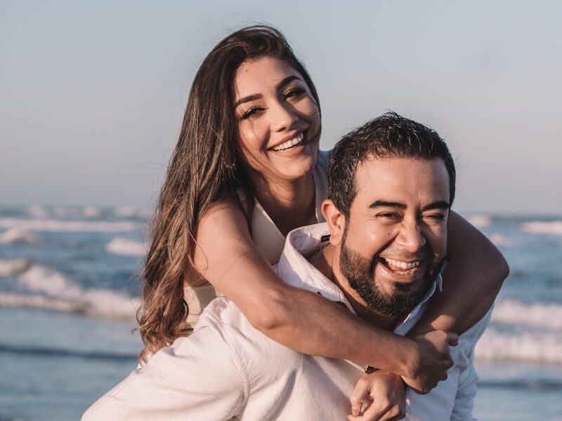 man in white dress shirt hugging woman in white dress