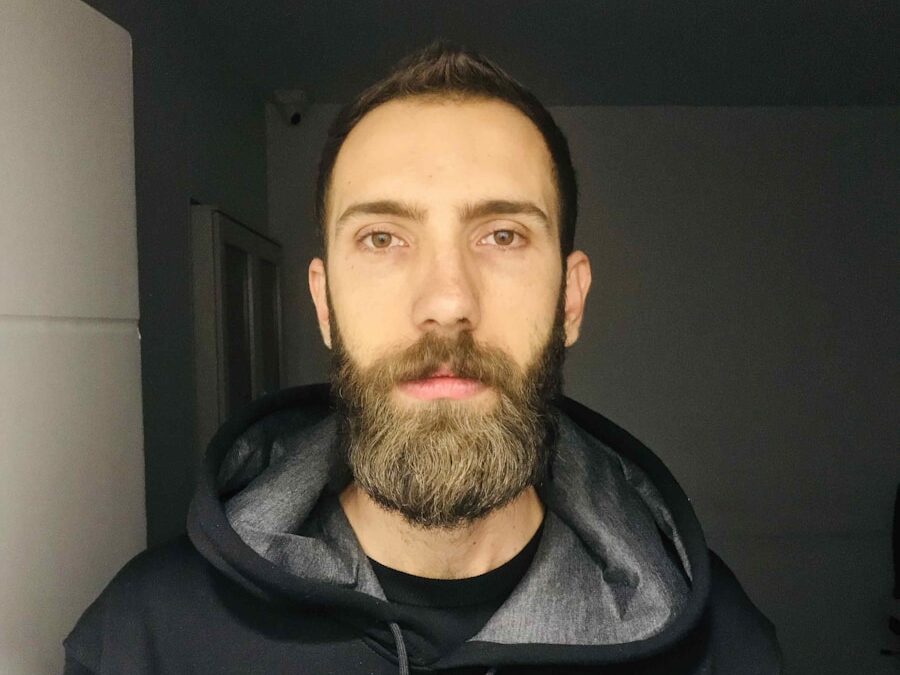 a man with a beard wearing a black hoodie