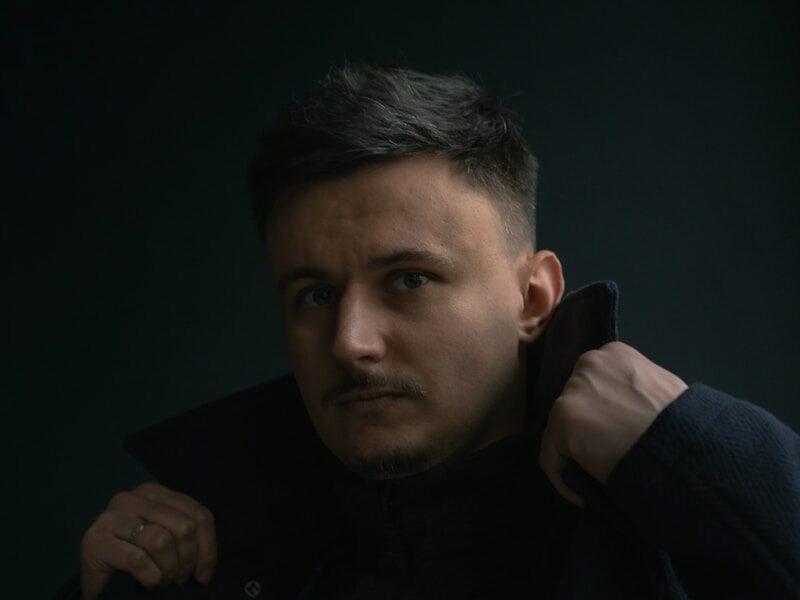 a man in a black coat posing for a picture