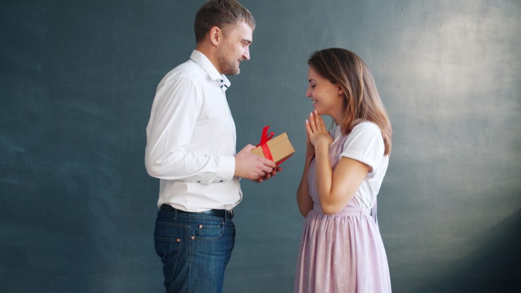 Man gives woman a gift with surprised joy