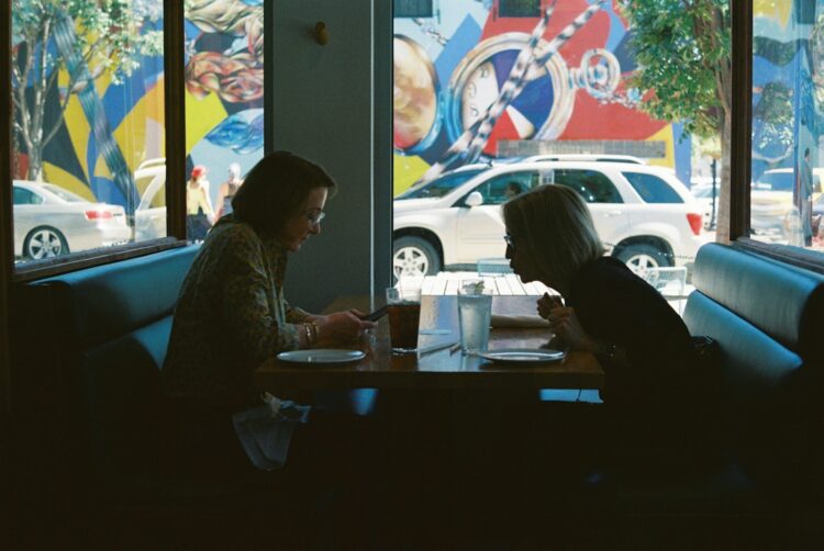 a man and a woman sitting at a desk in front of a window