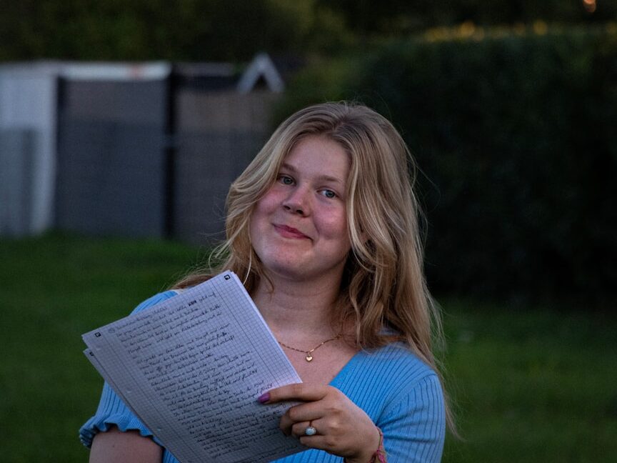a woman in a blue shirt is holding a book
