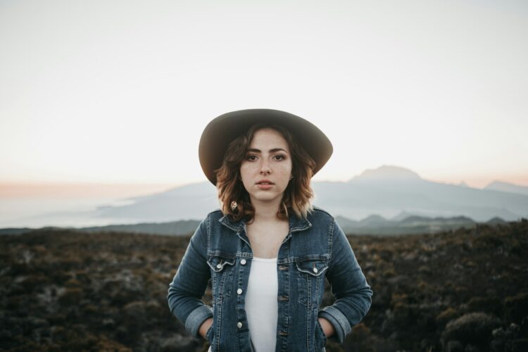 woman holding pouch of jacket standing on road