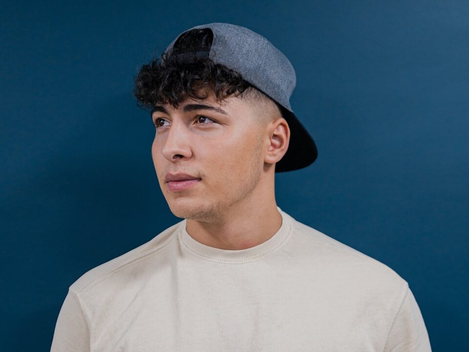 a young man wearing a hat and a t - shirt