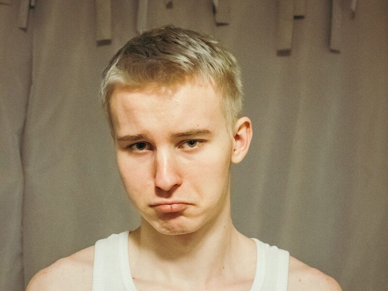 a man in a tank top is making a face