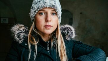 woman in black jacket wearing white knit cap