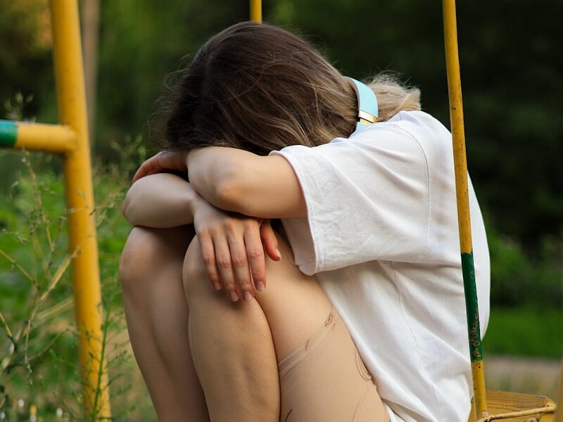 a woman sitting on a swing with her legs crossed