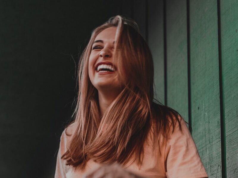 woman in orange shirt laughing