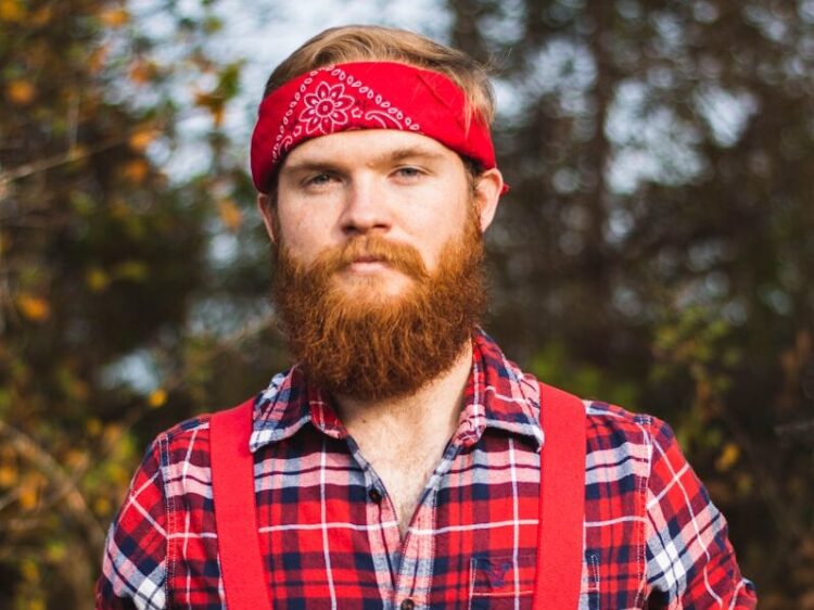 standing man wearing red and white floral kerchief close-up photo