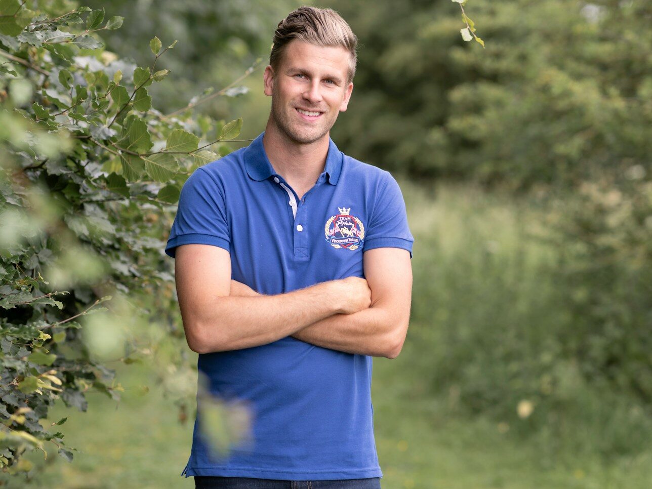 a man in a blue shirt is standing in the woods