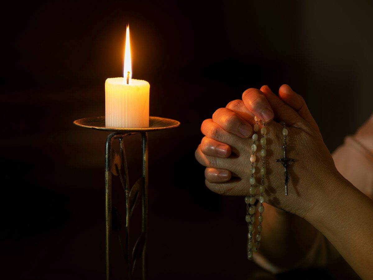 person holding white pillar candle