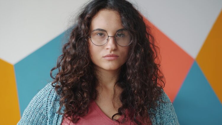 Young woman with curly hair and glasses