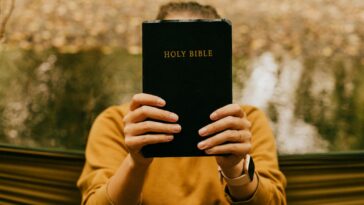 person holding black book during daytime