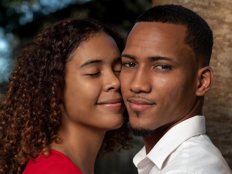 man in white dress shirt beside woman in red long sleeve shirt