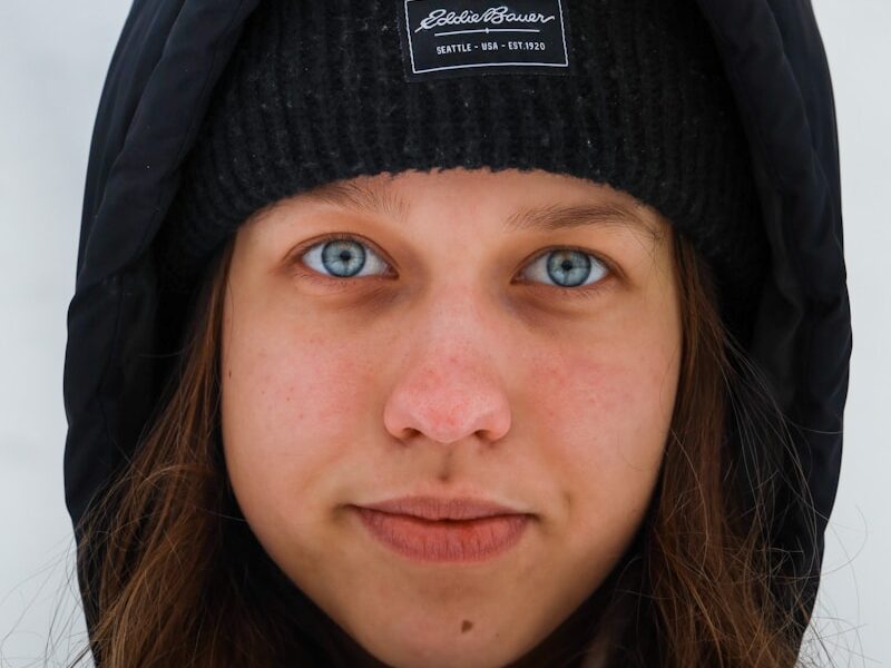 a woman with blue eyes wearing a black hat