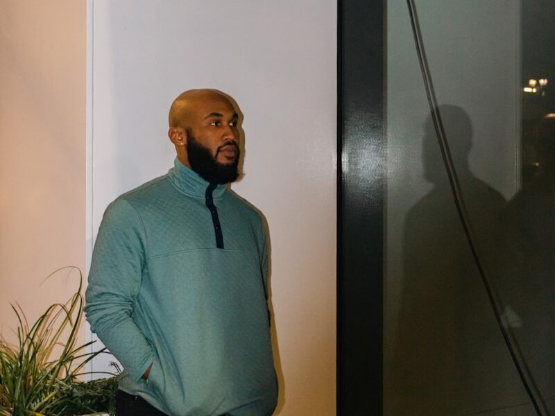 a man standing next to a plant in a room
