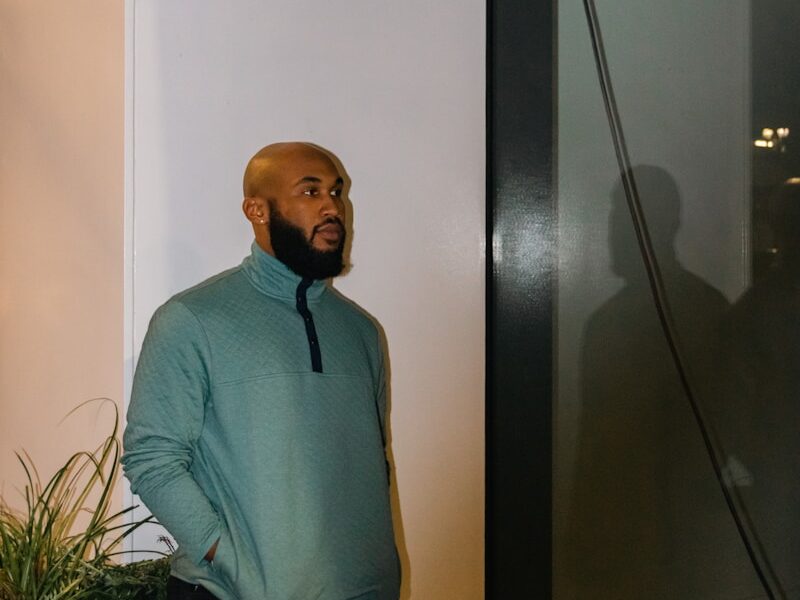 a man standing next to a plant in a room