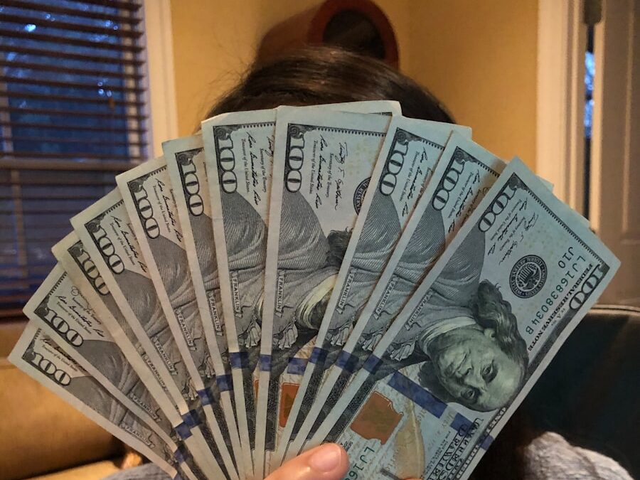 person holding fan of us dollar bill