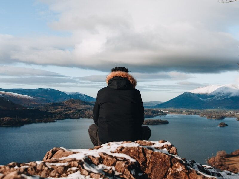 man sitting on mountain peak
