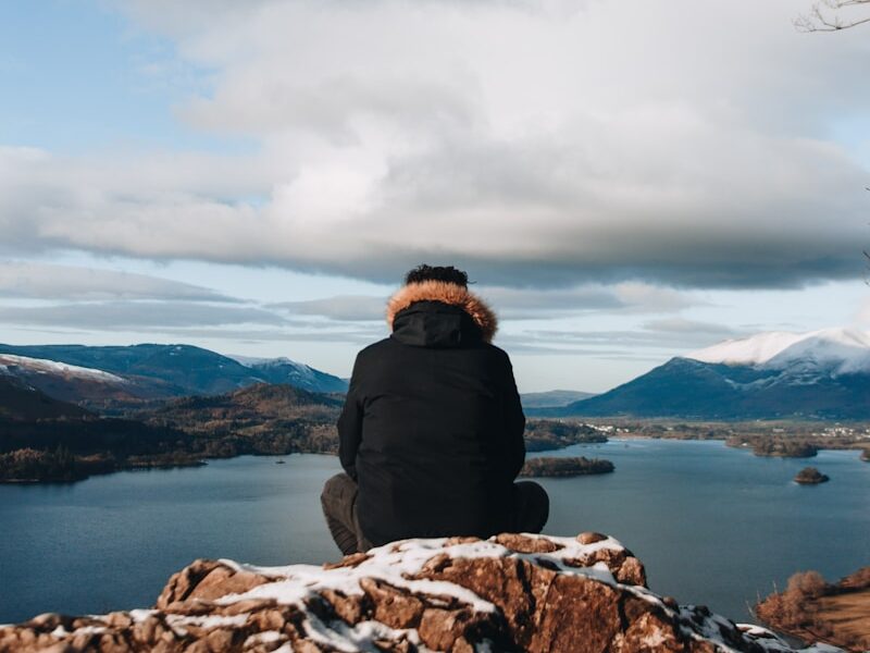 man sitting on mountain peak