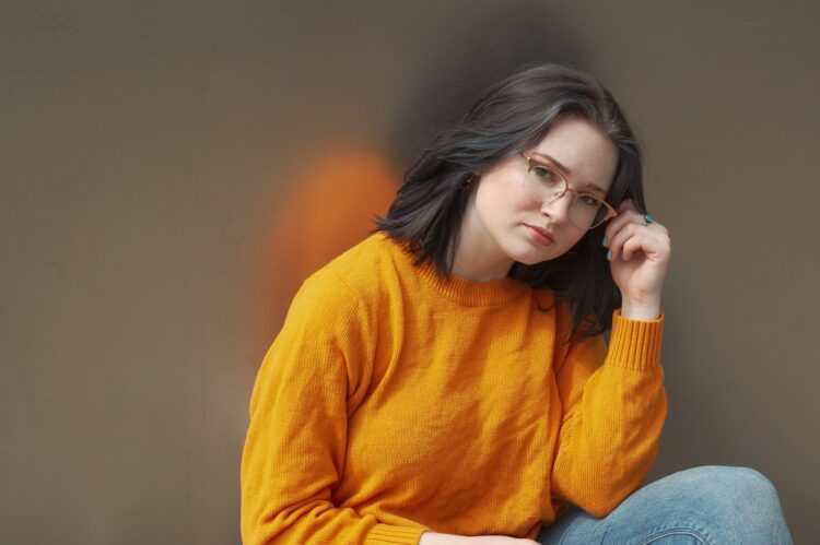 woman holding her eyeglasses