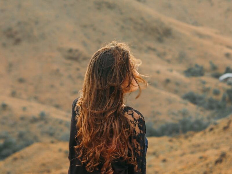 woman in black shirt looking at the mountains during daytime