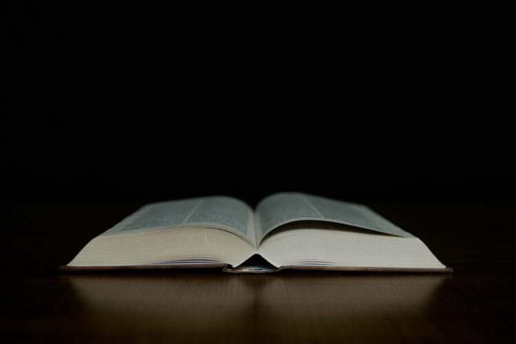 an open book sitting on top of a wooden table